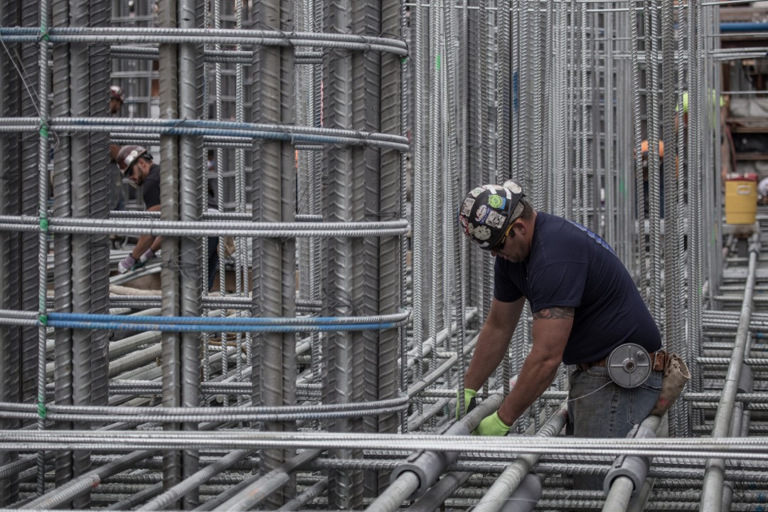 Ironworkers arrange layer upon layer of steel reinforcements in
